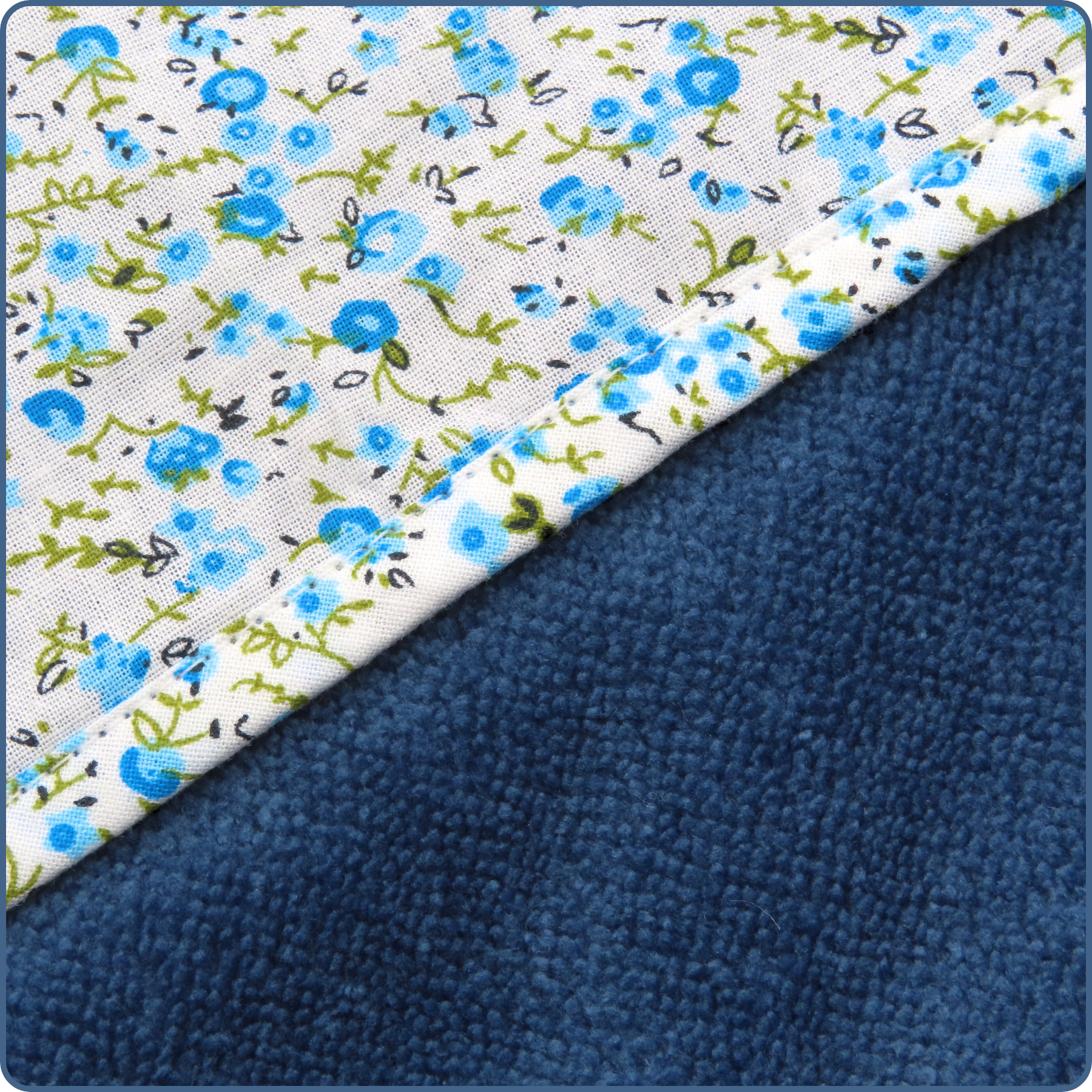 Zoom sur motif fleurs bleues, cape de bain bébé, en tissu bambou Oeko-Tex, taille 0-4 ans, cousue main par Terre de Baïnes.
